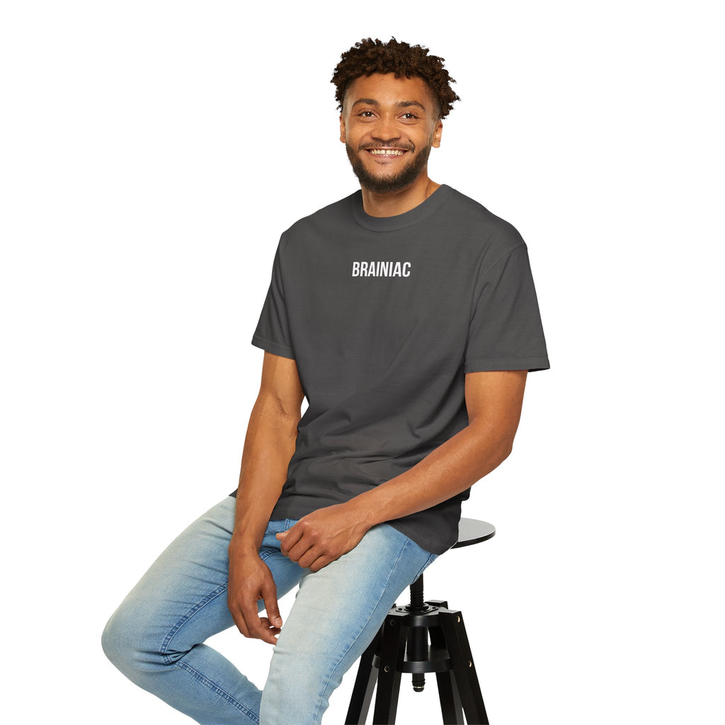 Man sitting on a stool wearing a graphite t-shirt with 'BRAINIAC' text.