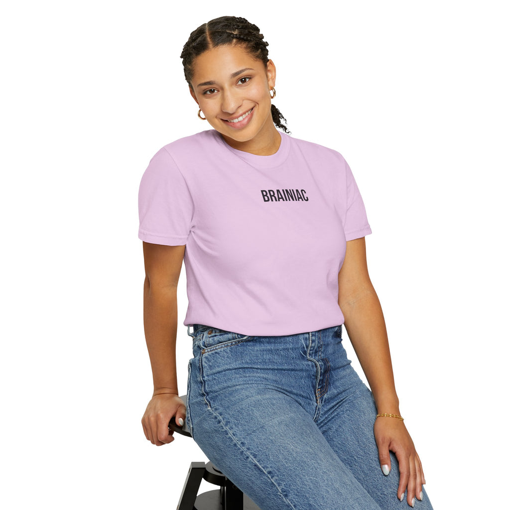 Person wearing a light purple t-shirt with 'BRAINIAC' text and blue jeans, sitting on a stool against a white background.