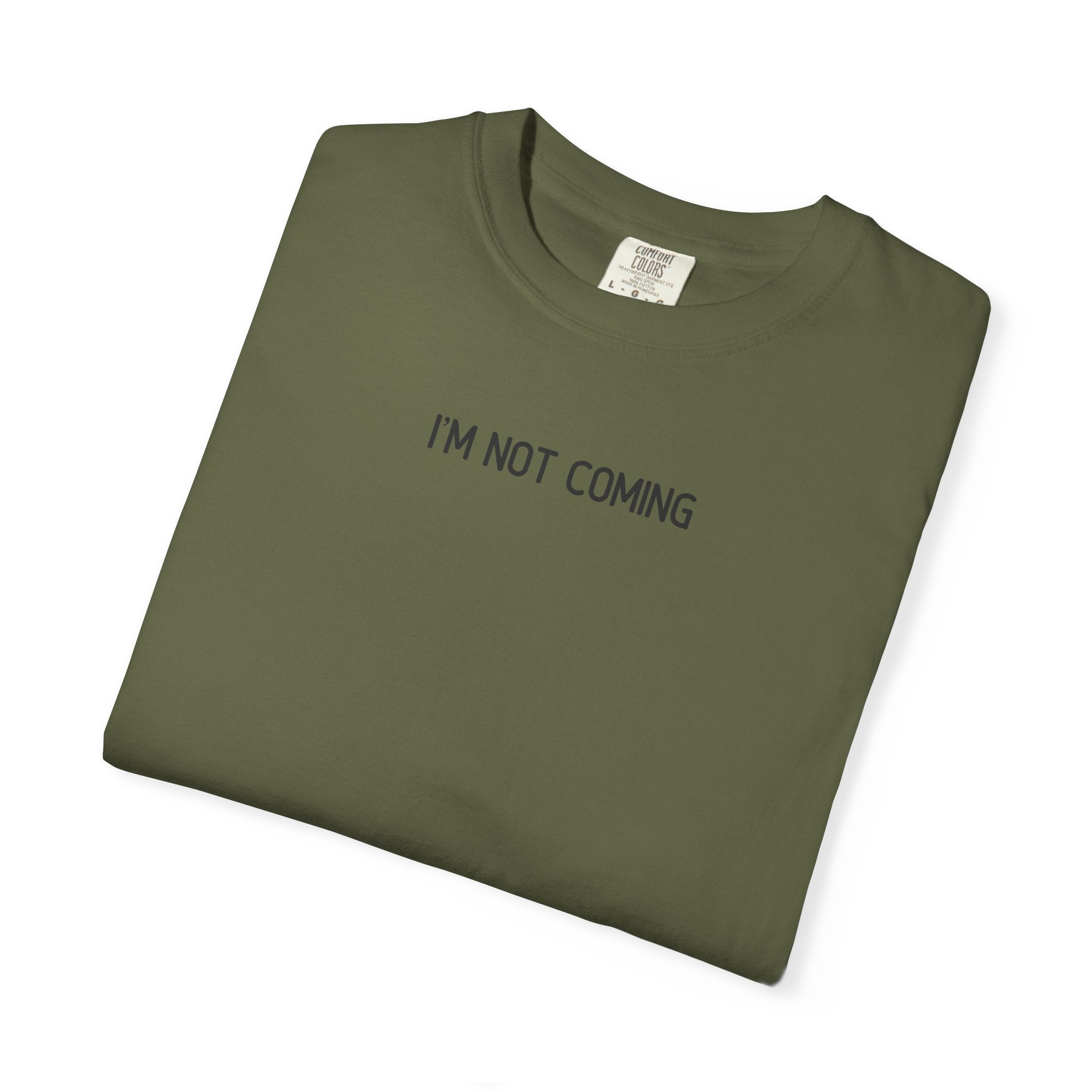 Folded green t-shirt with 'I'M NOT COMING' text on a white background